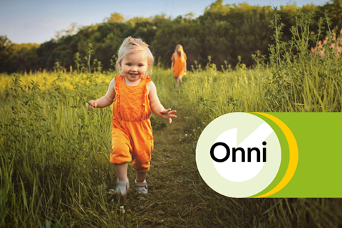 Pieni iloinen lapsi juoksee pellolla, takana näkyy myös vanhempi oranssiin mekkoon pukeutunut lapsi. Onni-hiilineutraali kaukolämpö, logo on kuvassa oikeassa reunassa.