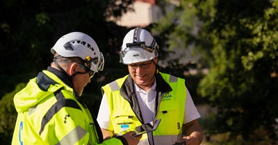 Kaksi Oulun Energian Sähköverkko Oy:n työntekijää juttelevat keskenään ulkona. 