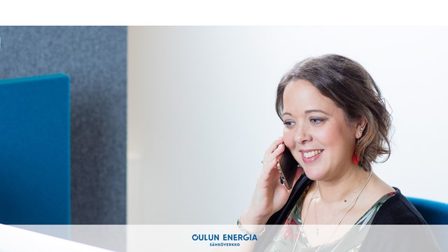 An Oulun Energia customer service agent answering the phone with a smile.