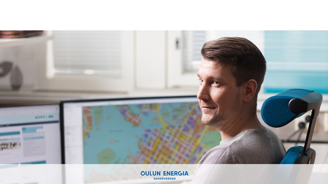 Oulun Energia employee sitting in front of a computer.