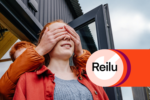 A young man is covering young woman's eyes by his hands, Reilu logo is on the right side.