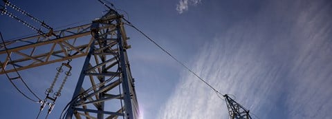 A piece of electricity tower, sky as a background.