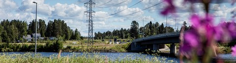 Sähköverkot ylittävät Oulujoen kesällä.