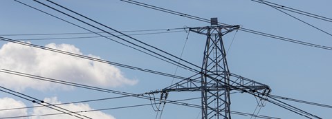 Electricity tower's peak against blue sky.