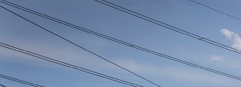 Sähkölinjoja kuvattuna kirkasta taivasta vasten.