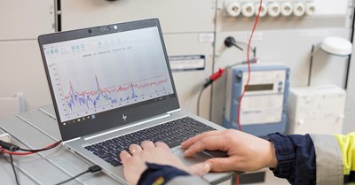 Kannettavalla tietokoneella näkyy energiankulutuksen grafiikkaa. Henkilö katsoo kulutustietoja.