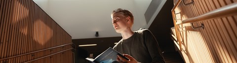  A young person reads a non-fiction book in the library.