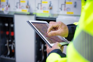 An employee of Oulun Energia Electricity Network is looking at a map on a tablet.