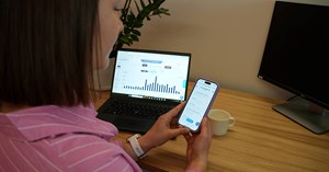 Kuvassa henkilö selaa Oulun Energian mobiilisovellusta puhelimelta. Näkyvissä on myös tietokoneella OE Digipalvelu. 