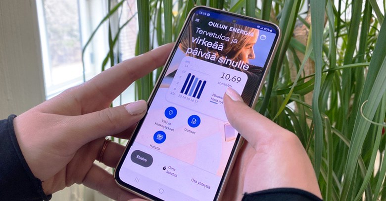 A person is scrolling through Oulu Energy app with their phone.