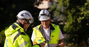 Kaksi OUlun Energia Sähköverkko Oy:n työntekijää juttelevat keskenään hymyssä suin. 