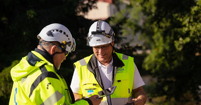 Kaksi OUlun Energia Sähköverkko Oy:n työntekijää juttelevat keskenään hymyssä suin. 
