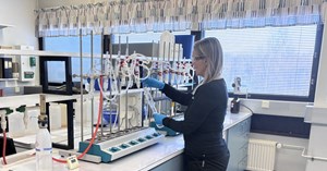 Voimalaitoskemian laboratoriossa nainen työskentelee näytteenottoputkien kanssa. 