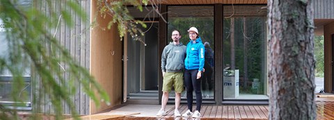 Omakotitalon rakentajat Kaisa ja Jari seisovat uuden kodin terassilla yhdessä. Talo on kaksikerroksinen.