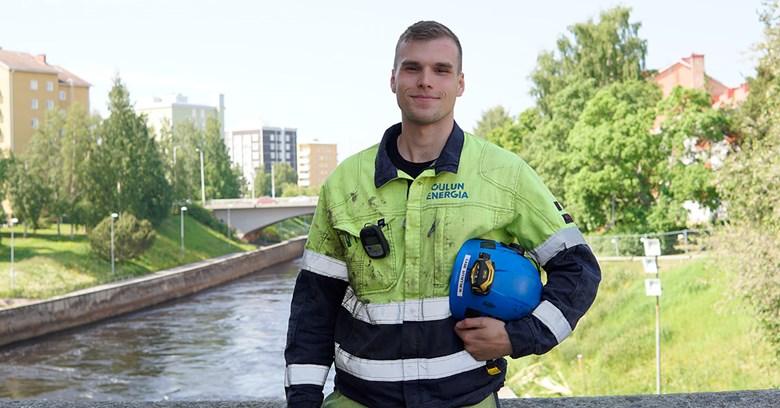 Sami Hynynen Merikosken vesivoimalaitoksella. Sami hymyilee kameraan ja pitelee kypärää kädessään.