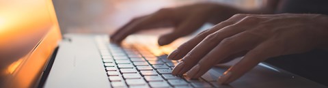 Hands on a computer keyboard.