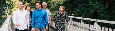 Oulun Energian työntekijöitä kävelemässä Ainolan puistossa ja juttelemassa iloisesti toisilleen.