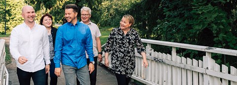 Oulun Energian työntekijöitä kävelemässä Ainolan puistossa ja juttelemassa iloisesti toisilleen kesällä.