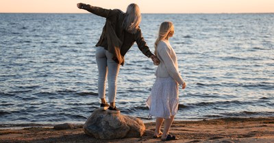  Two girls on the beach. Summer evening and windy.