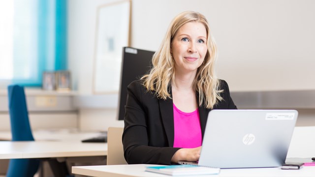 Oulun Energia employee poses with a laptop.