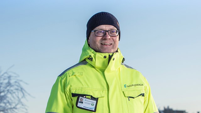 Oulun Energian työntekijä katsoo hymyillen kameraan. Kuva on otettu talvella.