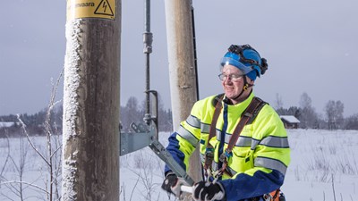 Oulun Energian työntekijä työskentelee sähkötolpan luona.