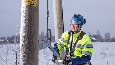 Oulun Energian työntekijä työskentelee sähkötolpan luona.